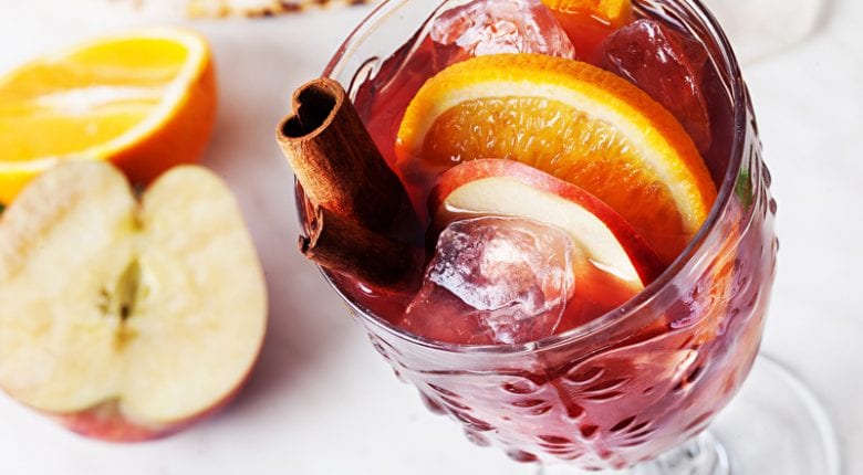 Sangria in a glass ice orange apple cinnamon on top cold wine