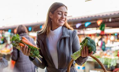Women with carrots and broccolis in hands