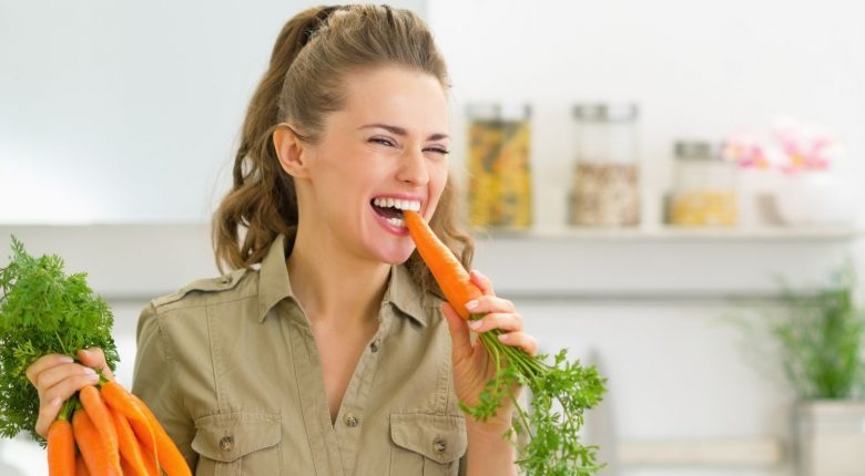 Woman eating carrot