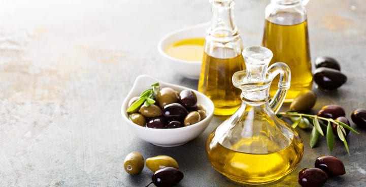 olives öl hinein weinlese flaschen mit schwarz und grün oliven blätter copyspace auf rustikal hintergrund